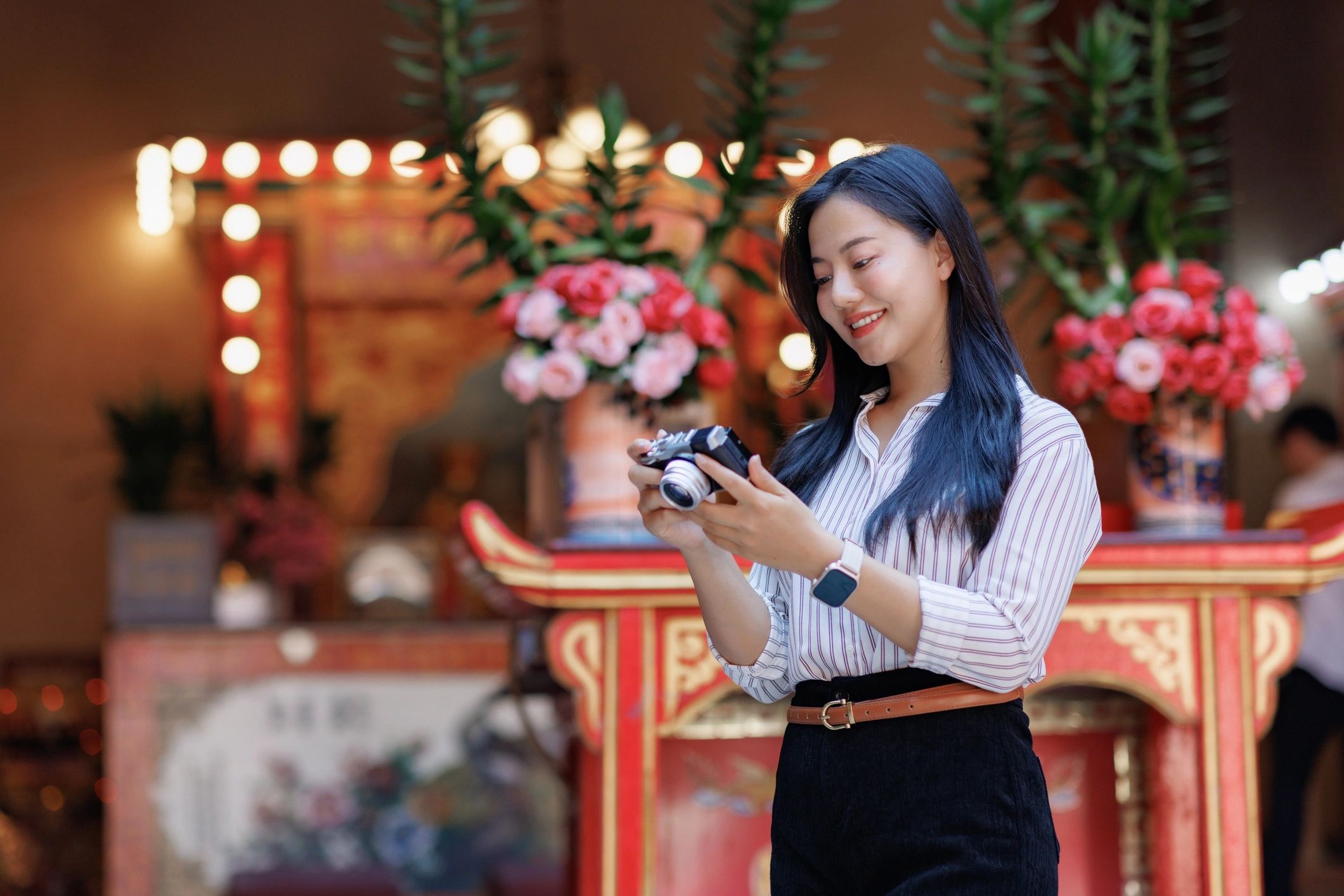 Woman holding a vintage camera and smiling